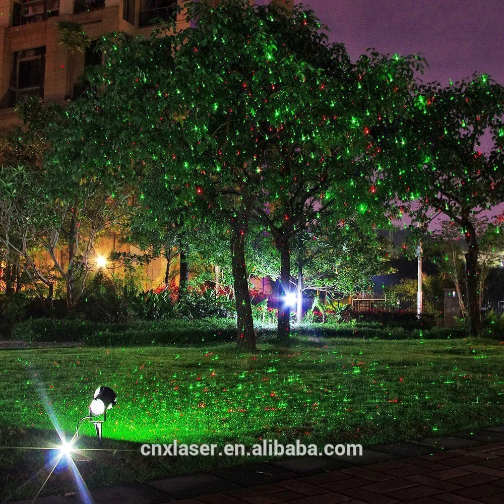 Christmas laser projector projecting red and green laser firefly patterns onto a garden tree at night, IP65 outdoor use