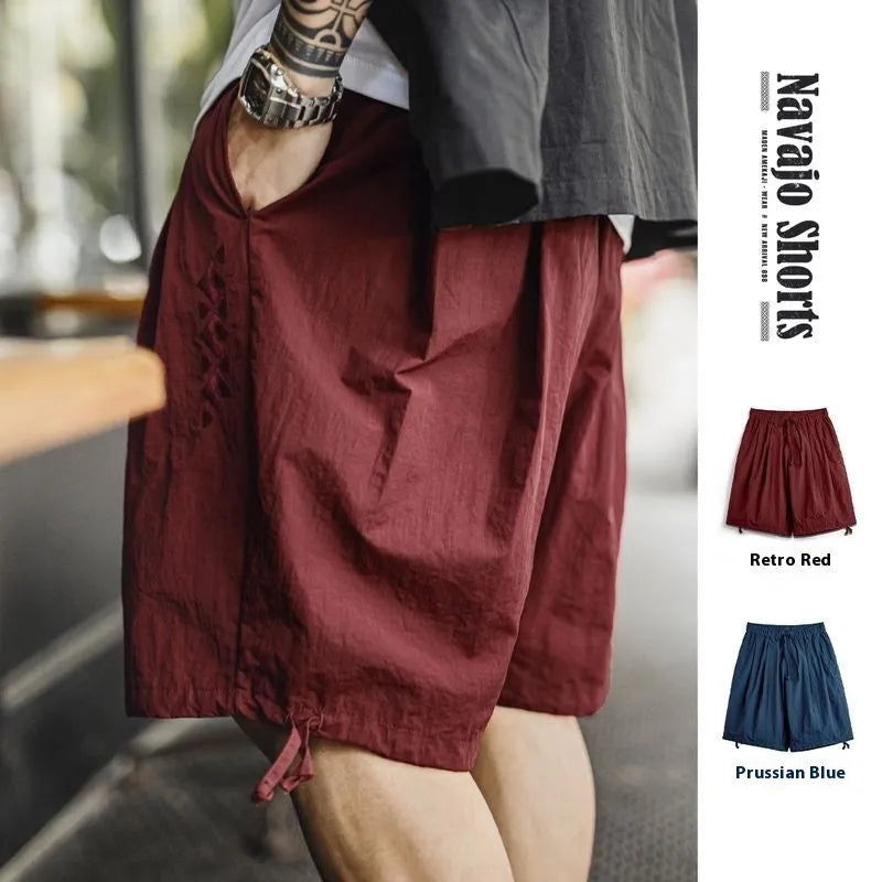 Men's loose-fit nylon beach shorts in Prussian blue colour with embroidered design details