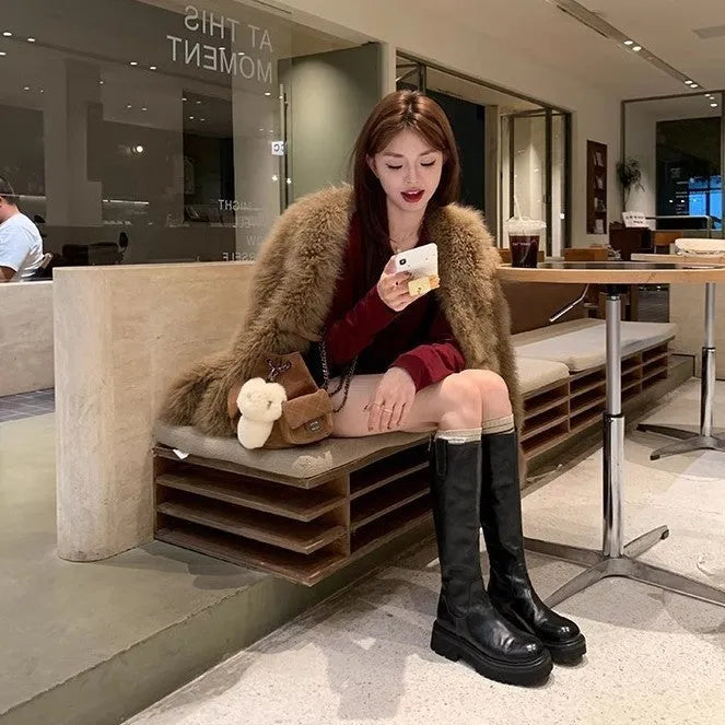 Women's black knee-high round toe boots with a chunky heel and back zipper on a white background.