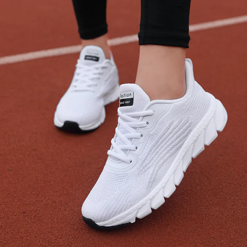 Low-top black and white running sneakers with cross-strap detail and flat MD sole.