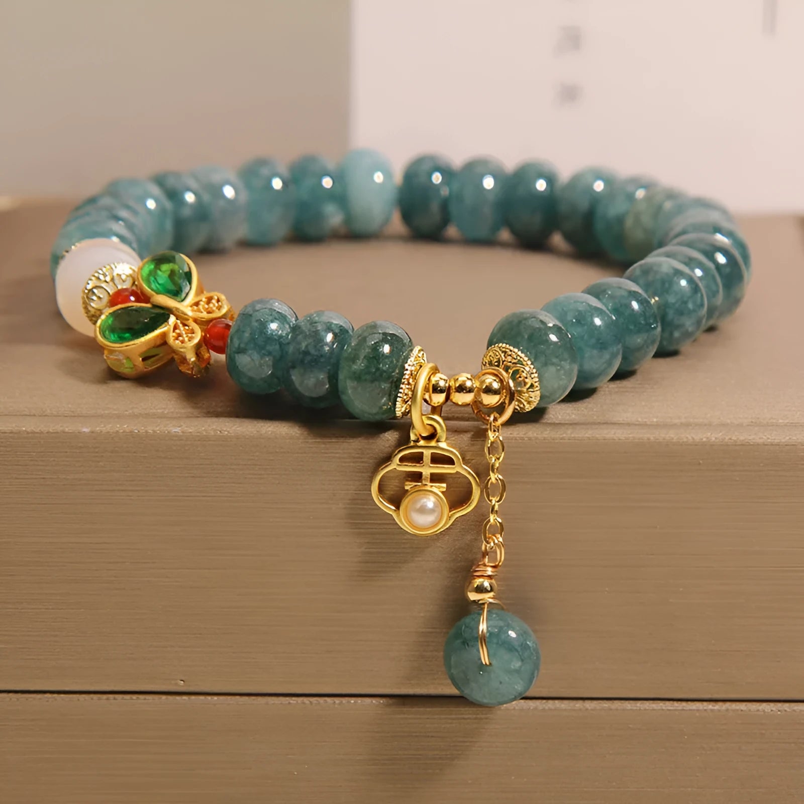 Blue water jade and white agate abacus bead bracelet with alloy inlay, rhinestones, and butterfly charm.