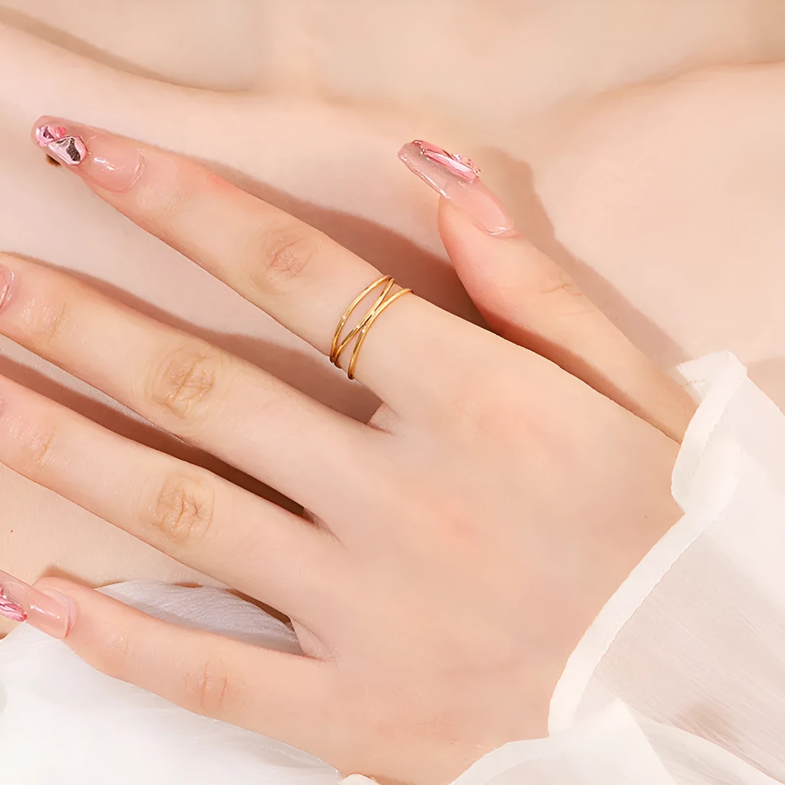 Gold geometric coil ring on a plain background, showing its three-layer titanium steel construction