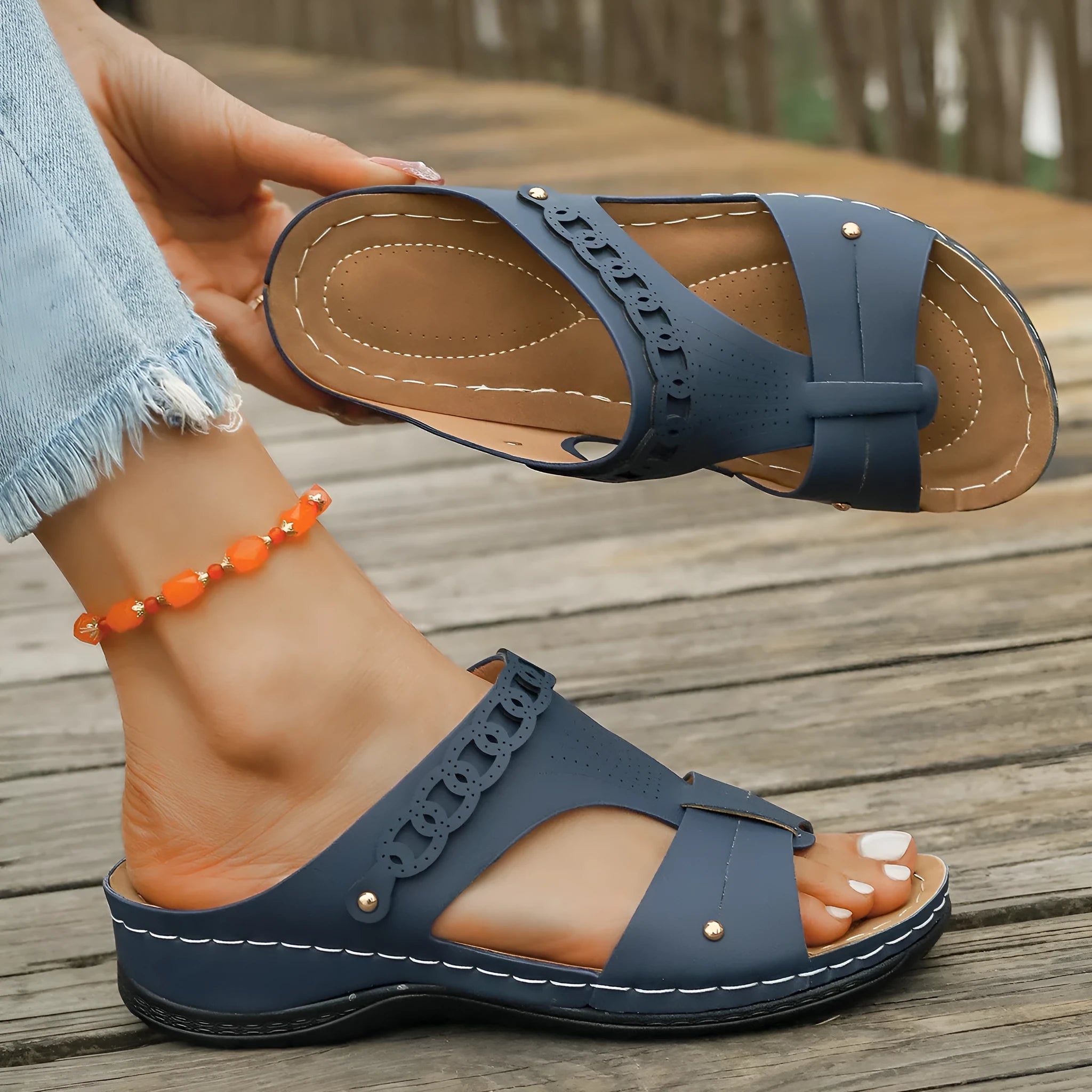 Blue Roman style casual slippers with a slope heel and fish mouth toe holder on a rubber sole.