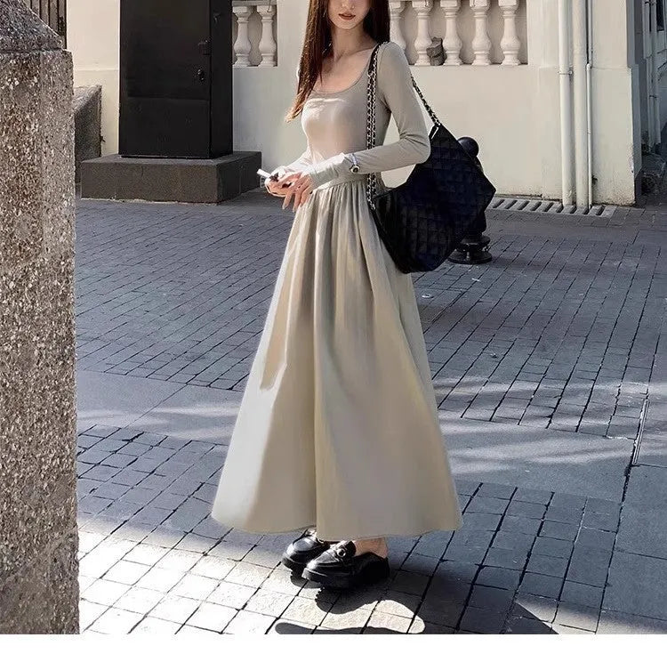 Women's black knitted dress with square collar, long sleeves, and an elastic A-line skirt.