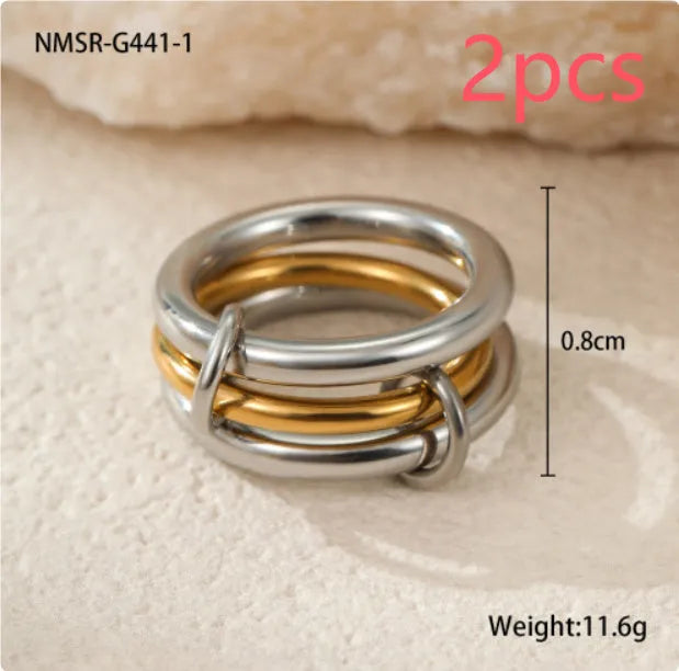Stacked stainless steel rings with 18K gold plating in multiple colour options on a woman's hand.