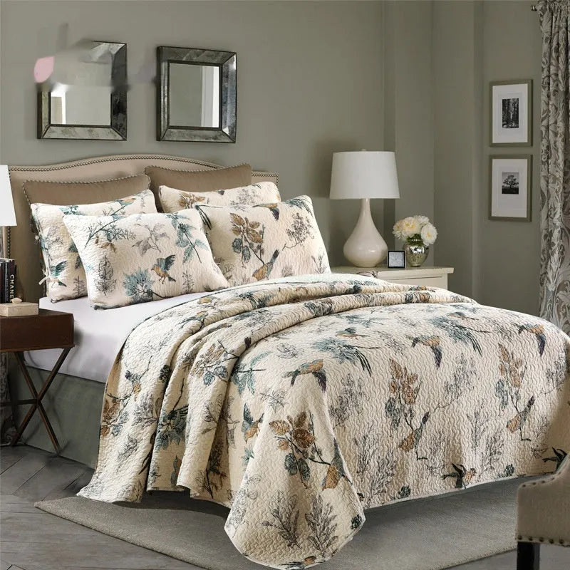Quilted pure cotton bedspread with decorative stitching and a colourful printed pattern, shown with matching pillowcases on a double bed.