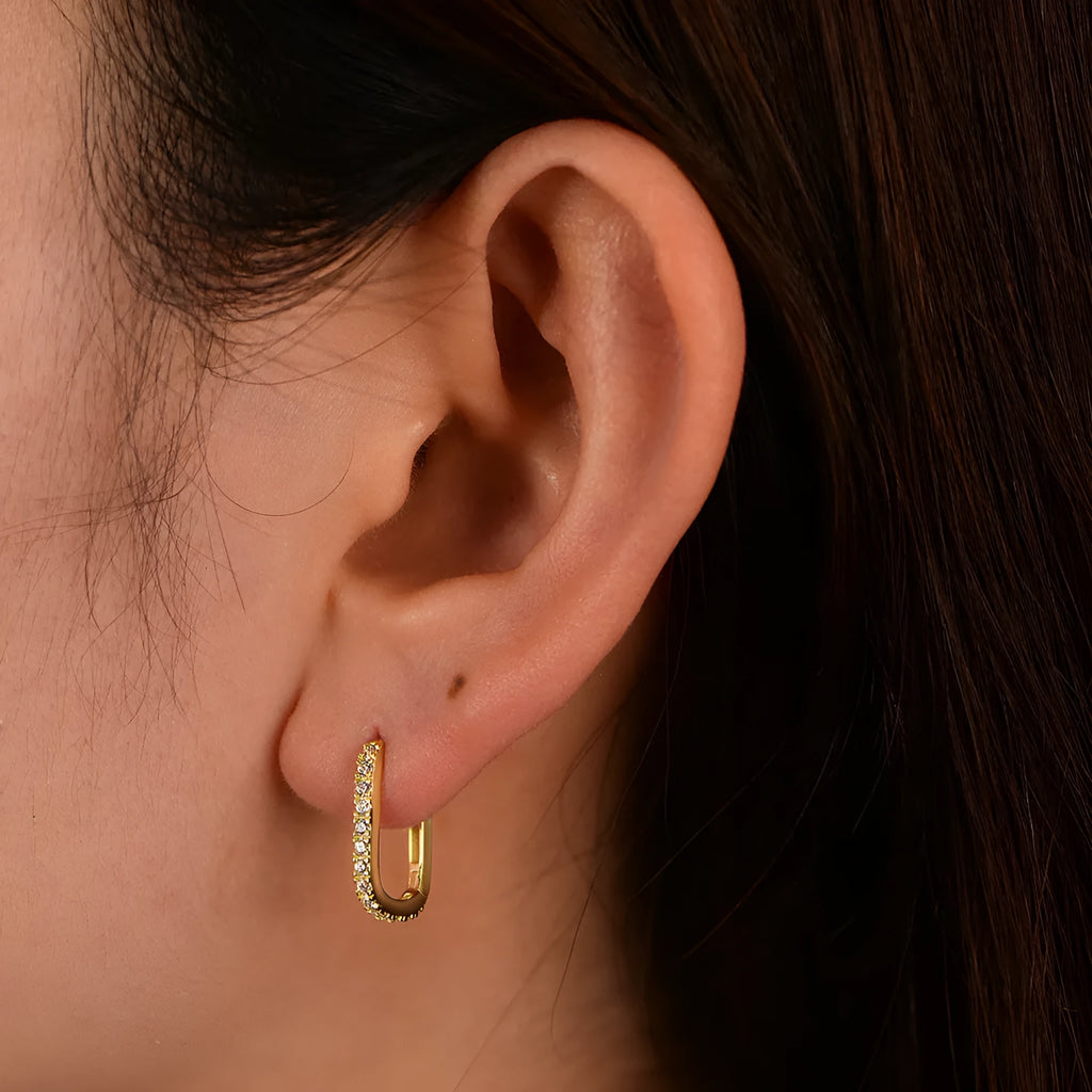 A pair of oval geometric sterling silver ear clips with zircon stones in white or yellow colour.
