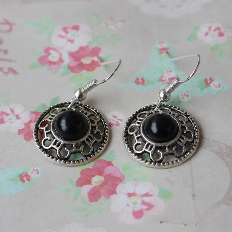 Handmade silver earrings with a turquoise stone and geometric flower disk ethnic design