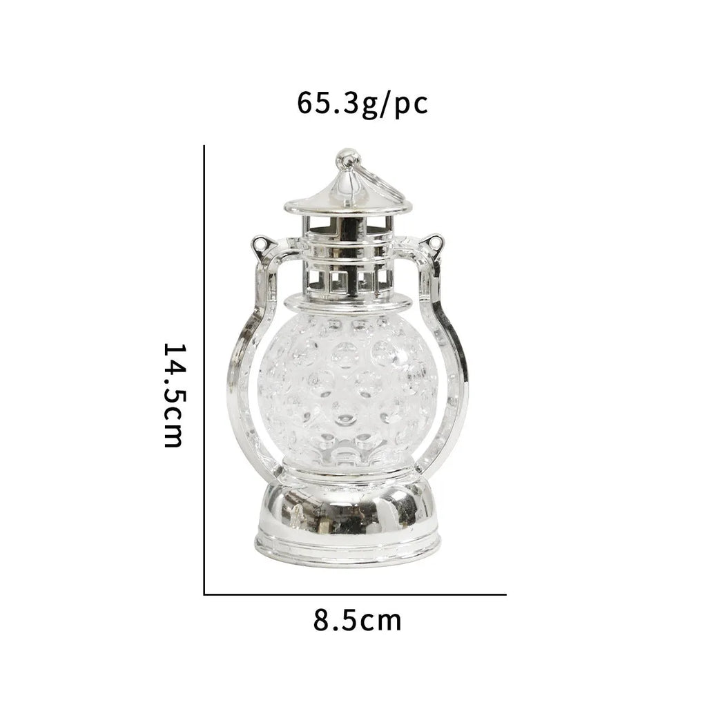 Small retro-style oil lamp LED night light in gold or silver finish on a table.