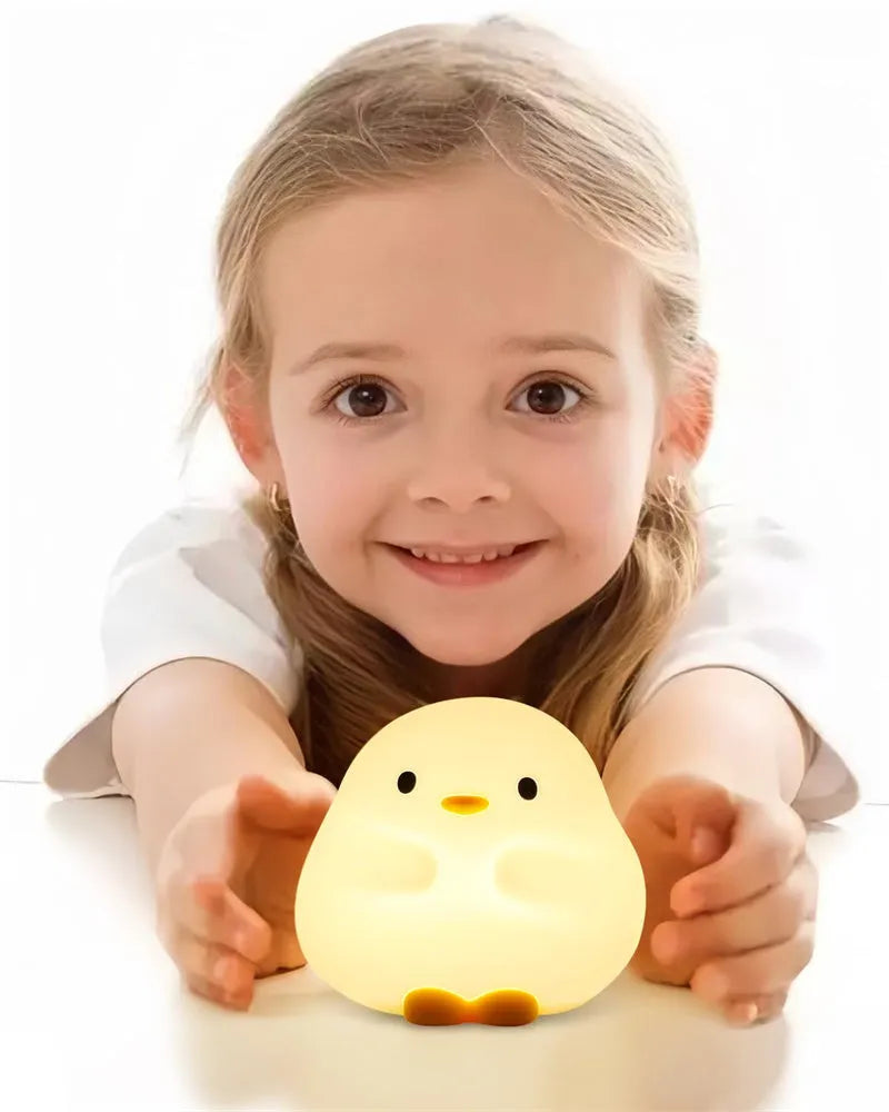 Cute duck-shaped silicone LED night lamp with touch sensor and warm glow on a bedside table