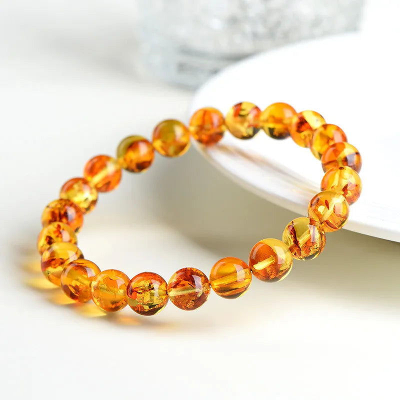 A natural yellow piebald amber bracelet with geometric beads for water purification.