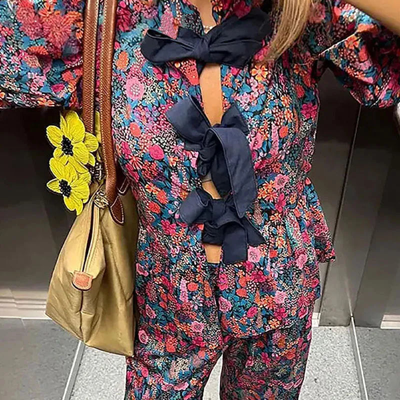 Women's floral print polyester trousers suit with puff sleeve top and matching trousers.