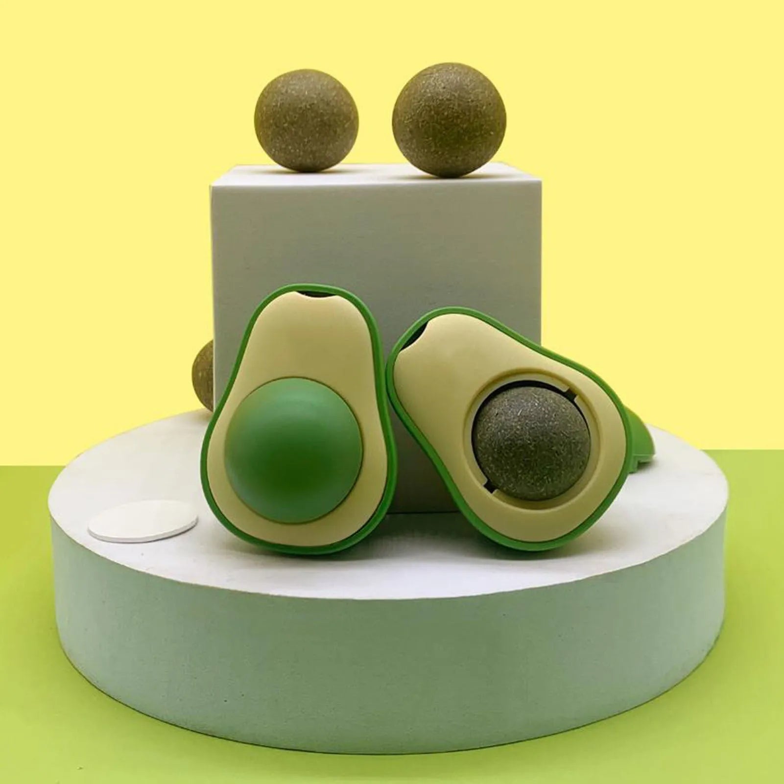Avocado-shaped catnip wall toy attached to a smooth window with a silvervine ball for cat teeth cleaning