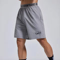 Man wearing loose black shorts with letter print, elastic waist, for sports and workout.