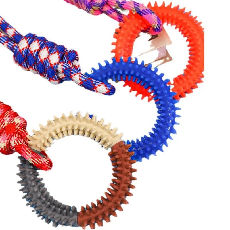 Blue, red, and rose red braided rope dog toy with a large central knot.