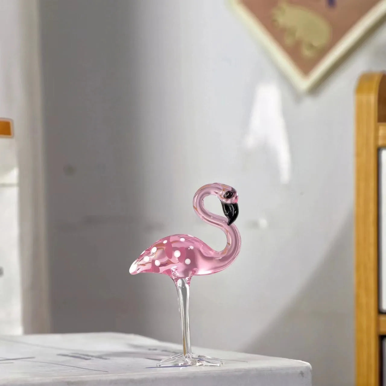 Pink flamingo decorative ornament made of white crystal on a table.