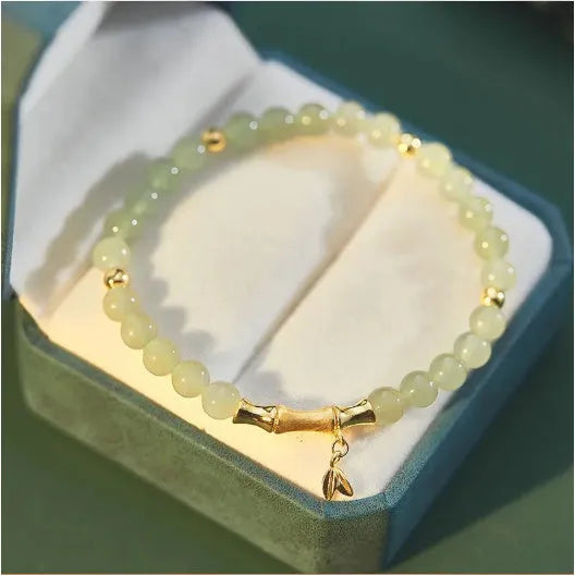 Bamboo-themed bracelet with a coloured glass flower and ruyi pattern in beige, green, light green, or white.