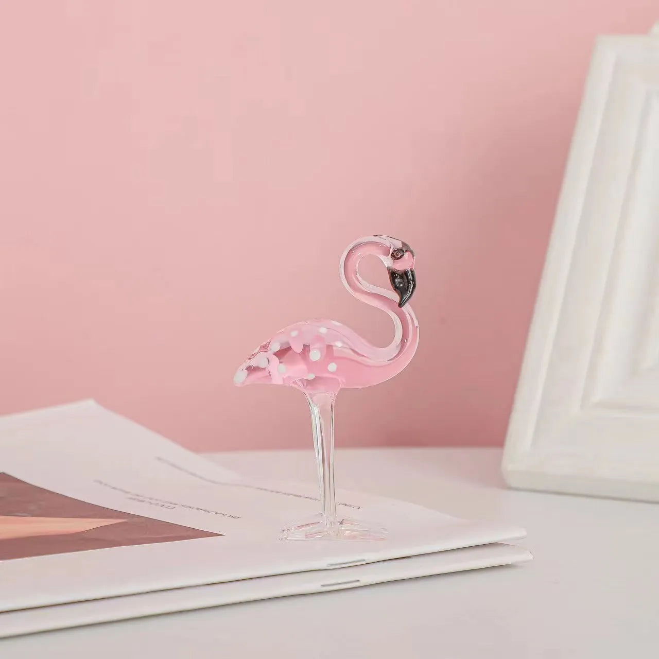 Pink flamingo decorative ornament made of white crystal on a table.