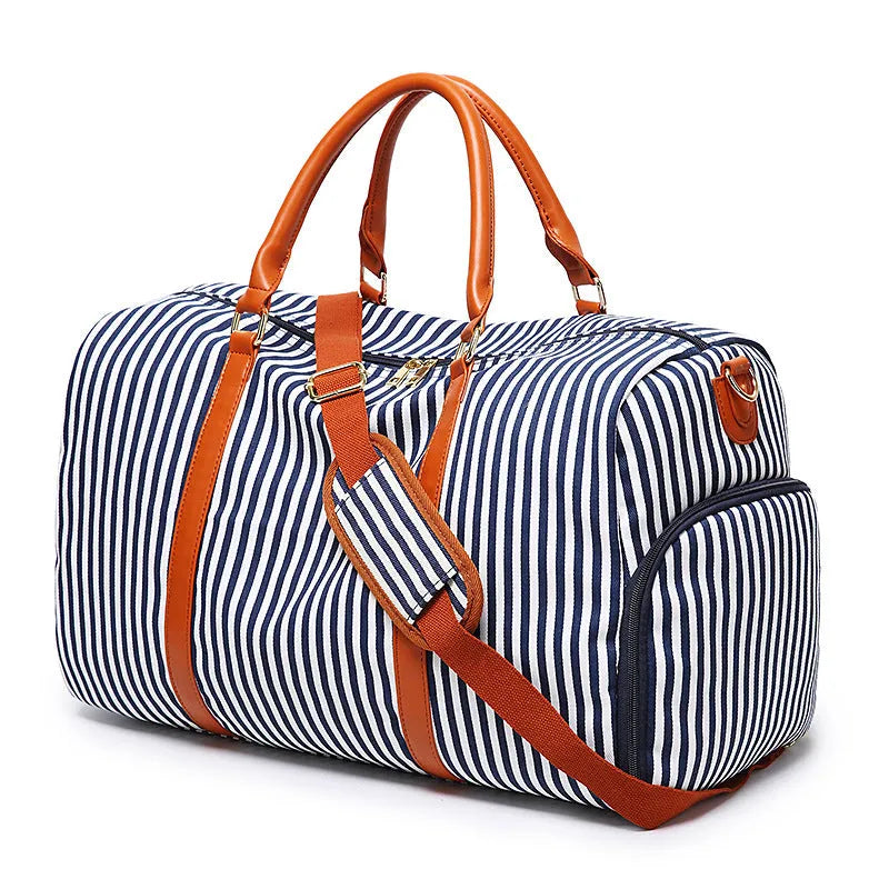 Large striped canvas travel duffel bag with contrast colour and leather detailing, horizontal square shape and zip top.