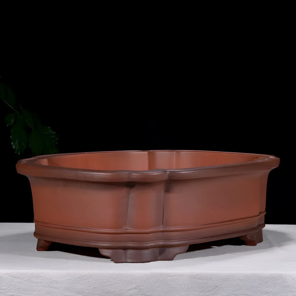 Large antique-style Chinese purple clay flowerpot with tree stump and floral relief pattern.