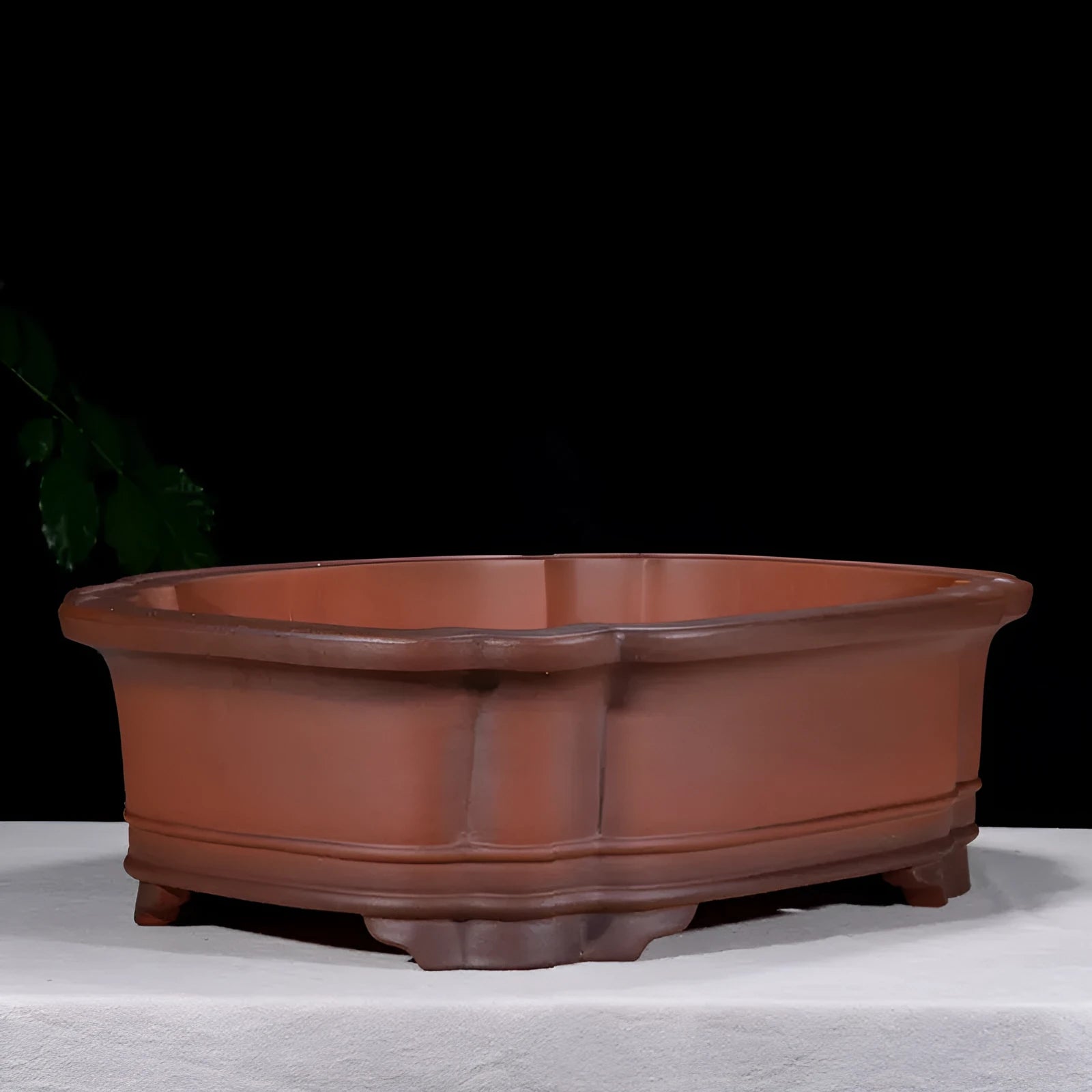Large antique-style Chinese purple clay flowerpot with tree stump and floral relief pattern.