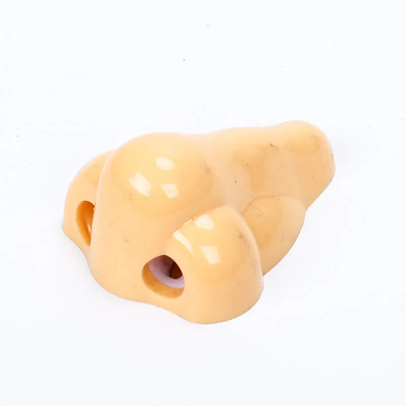 Flesh-coloured plastic student pencil sharpener with geometry design on a white background.