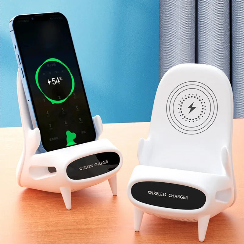 White mini chair-shaped wireless phone charger on a desk, with phone seated on it.