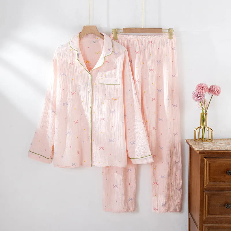 Women's beige thin cotton long sleeve pajama top and trousers set laid flat.
