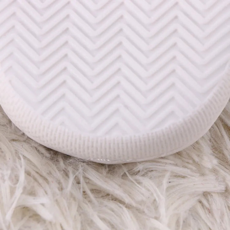 White cartoon pattern fluffy slippers with a non-slip rubber sole and toe holder design.