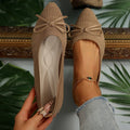 Women's knitted flat shoes with a bow detail and pointed toe in various colours on a plain background.
