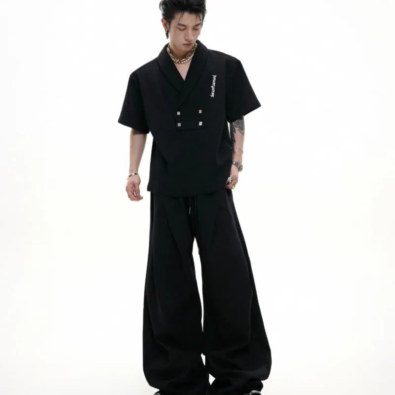 Men's dark grey V-neck padded shoulder short sleeve jacket with metal embellishments and matching shorts.