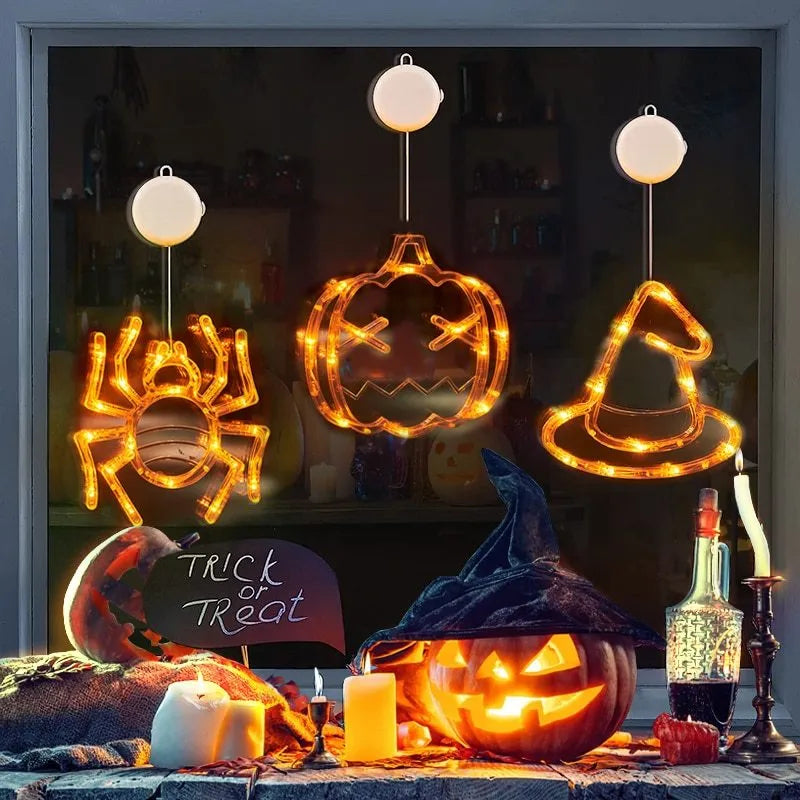 Halloween battery-powered LED window lights with spider, pumpkin and ghost figures hung by suction cups.