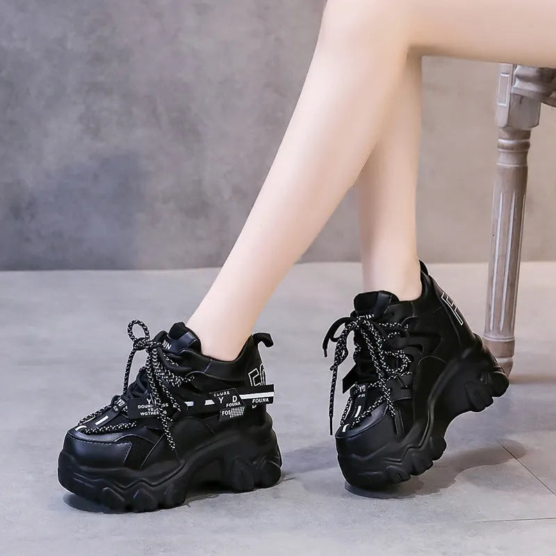 White women's low-top platform sports shoes with a cross-strap over a shallow-cut collar and a thick rubber sole.