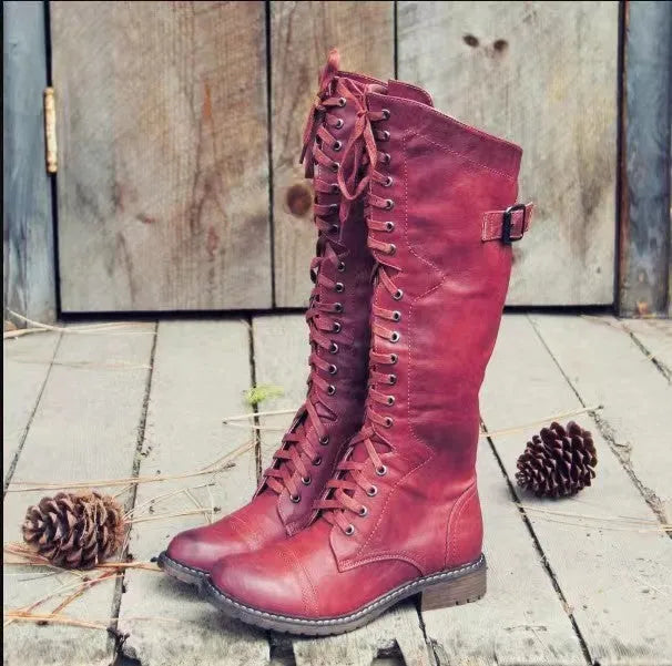 Black women's high-leg boot with a chunky low heel and round toe on a plain background.
