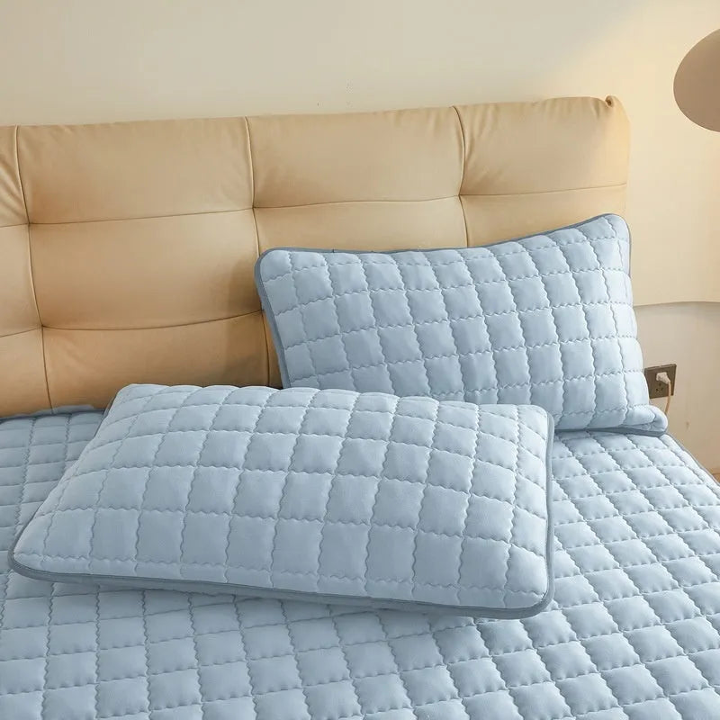 Blue waterproof fitted sheet with elasticated corners on a mattress.