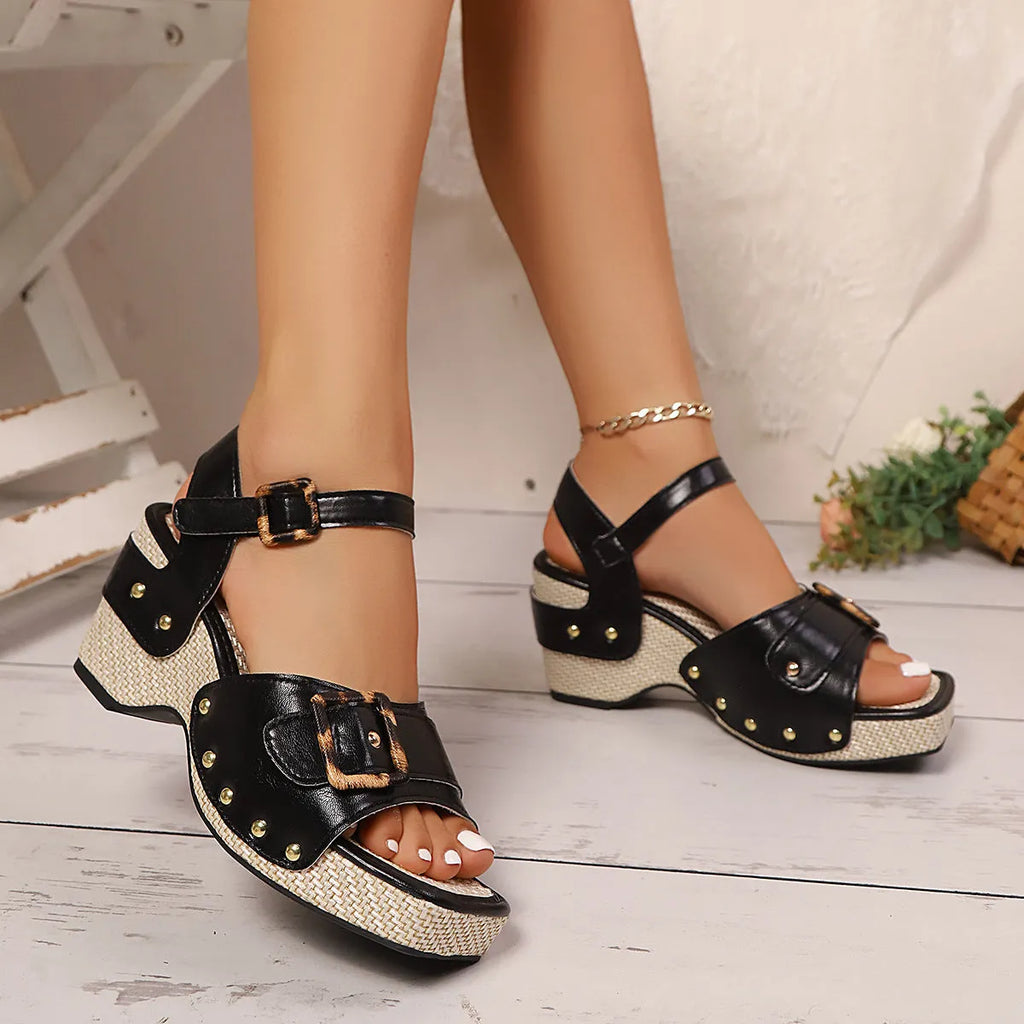 Women's black chunky heel sandals with a square toe and metal buckle fastening on a rubber sole.