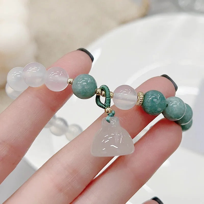 Close-up of a women's retro Chinese style agate bracelet with a carved lotus seedpod design.