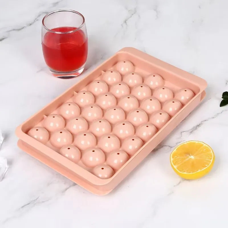 Blue flexible PE ice cube tray with lid, showing 33 round moulds, on a kitchen counter.
