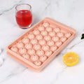 Blue flexible PE ice cube tray with lid, showing 33 round moulds, on a kitchen counter.