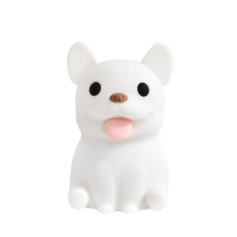 A cartoon bull-shaped silicone USB night light with a dimming function on a bedside table.