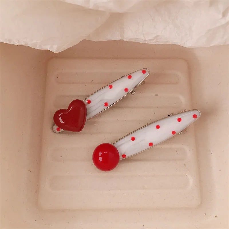 Red handmade hair clip shaped like a 3D love heart with vintage white dots, on a white background.