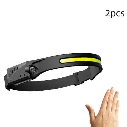 Black USB rechargeable headlamp with a wide COB LED lens and a side wave sensor on the headband.