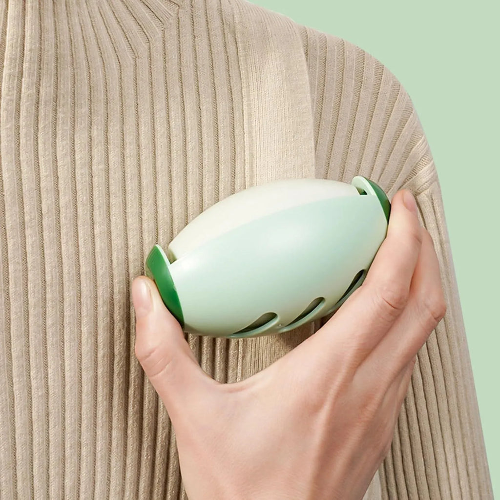 Green and white washable gel lint roller ball for pet hair removal on fabric.