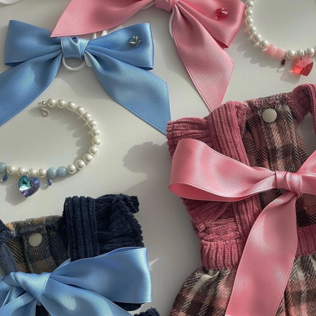 Blue princess style dog hair band with adjustable bow on a dog's head.