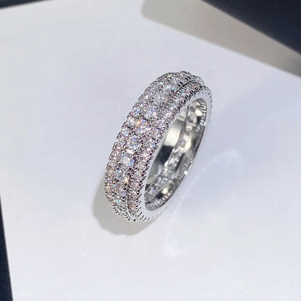Triangular geometric ring with a zircon stone centre, shown in different metal plating colours.