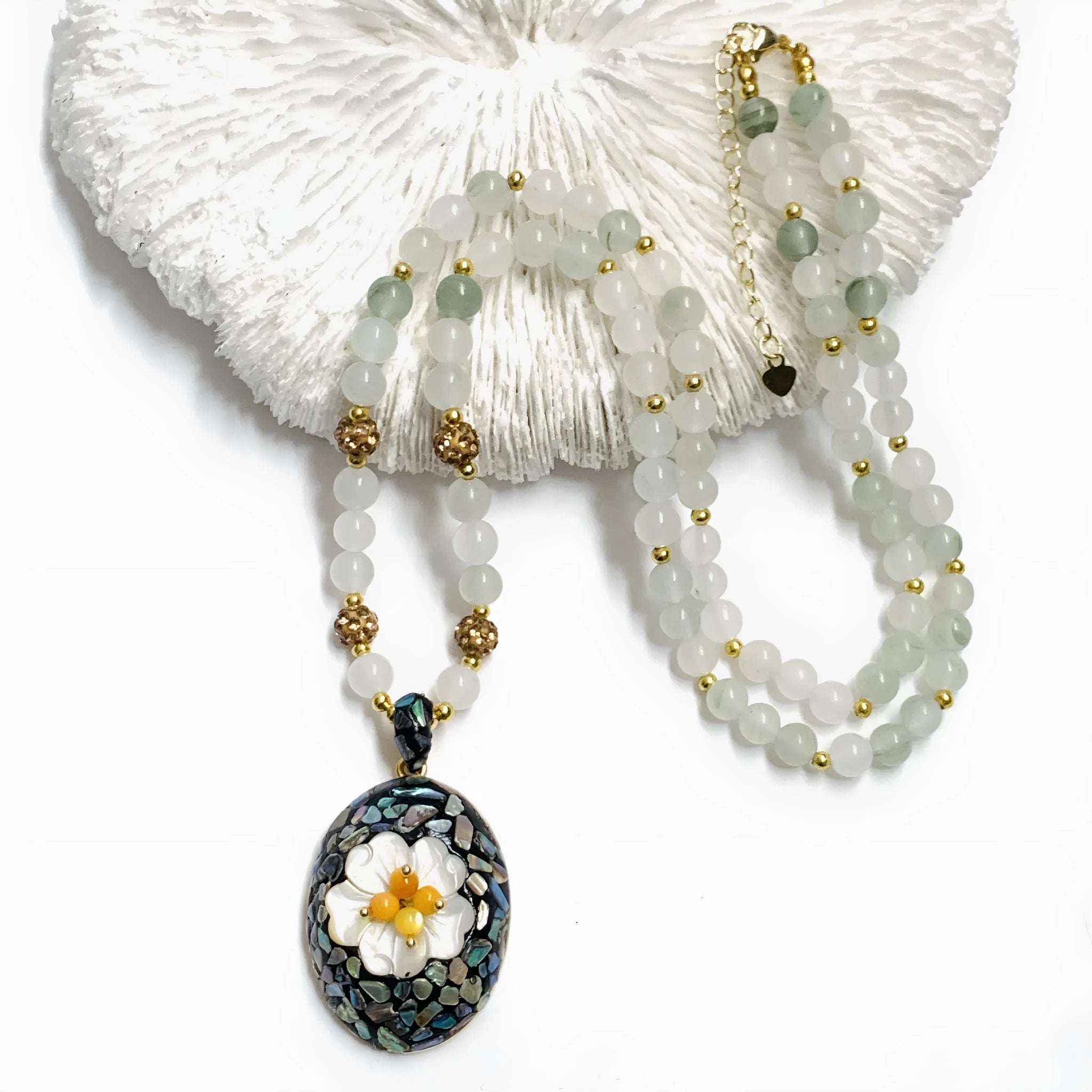 Original design mother-of-pearl lacquer shell necklace with rhinestone twist chain on display