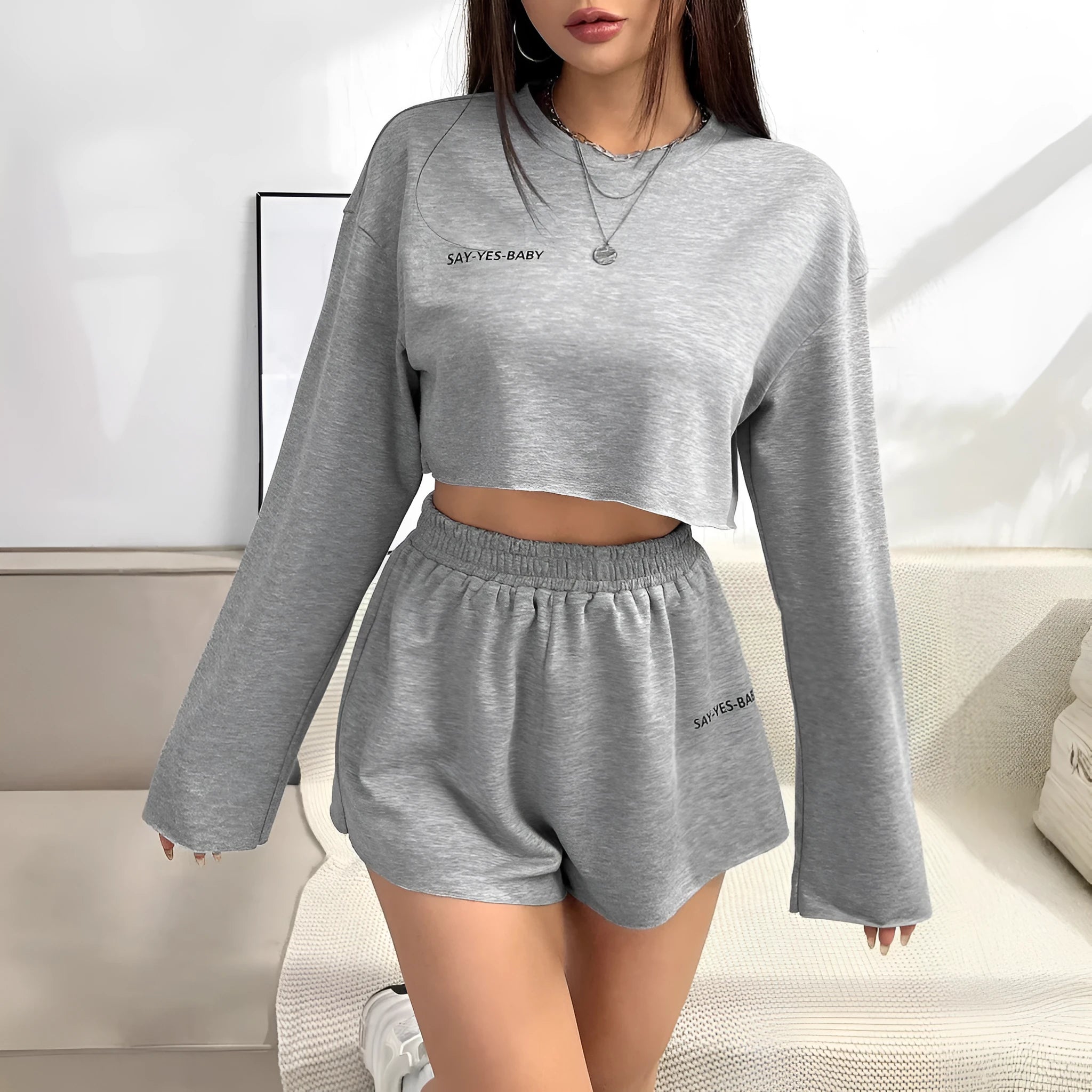 Grey women's long-sleeved t-shirt and matching shorts co-ord set laid flat.