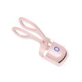 White USB rechargeable heated eyelash curler with dual temperature lights, shown next to its charging cable.