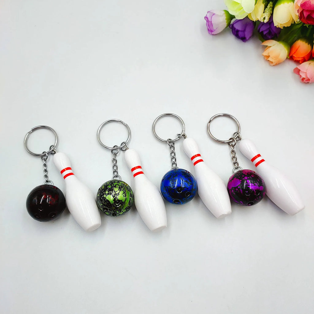 Mini bowling pin simulation keychain in blue, red, green, and purple colours on a metal ring.