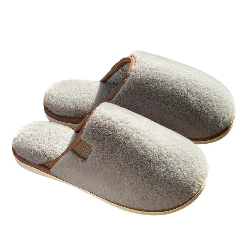 Pair of solid colour plush house slippers with a non-slip PVC sole, shown in coffee brown.